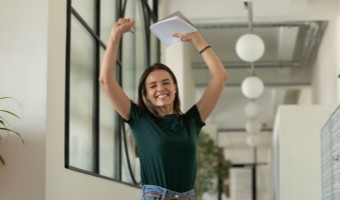 Photo of woman smiling with arms in the air