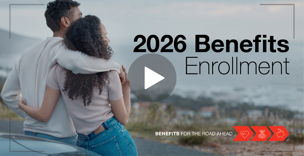 MagnaWebsite_ImageTile_VideoOverlay_02 Two people leaning against a car looking out at the town below and water