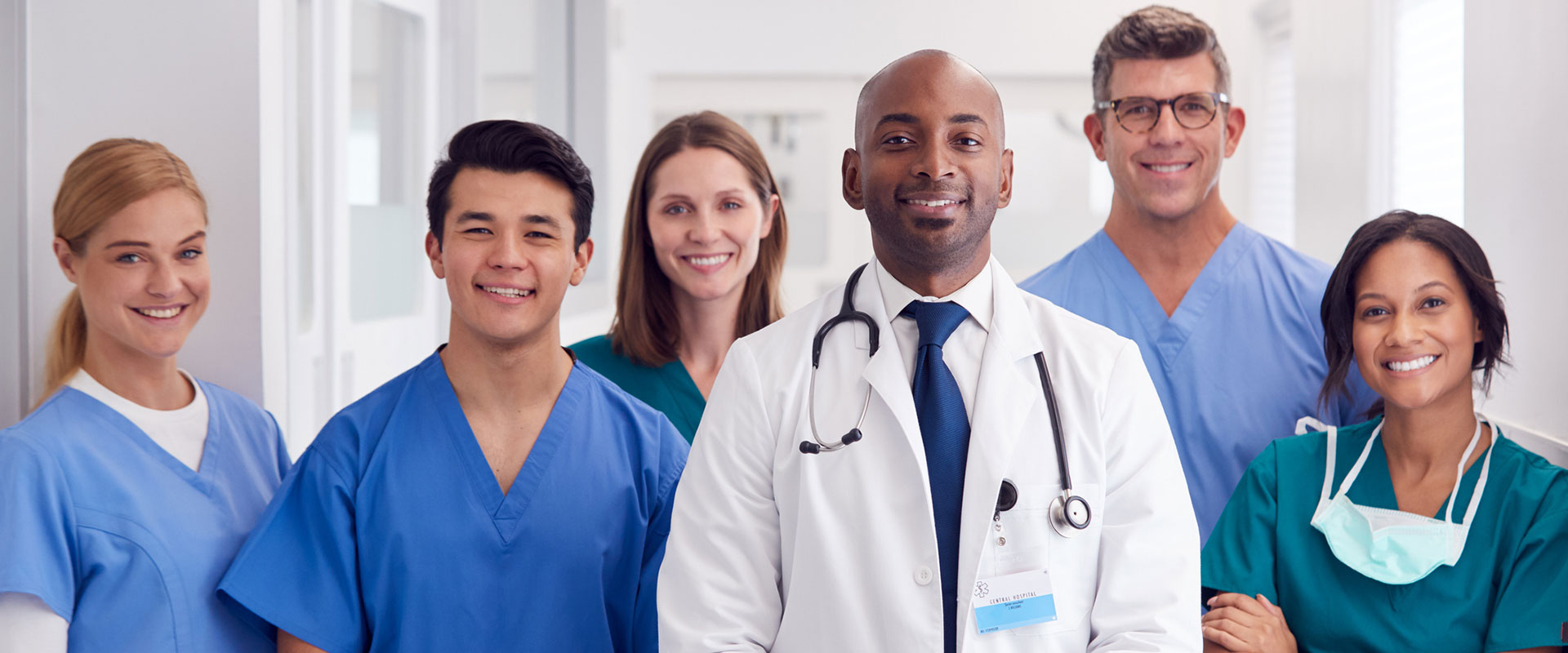 Group of doctors in scrubs standing and smiling