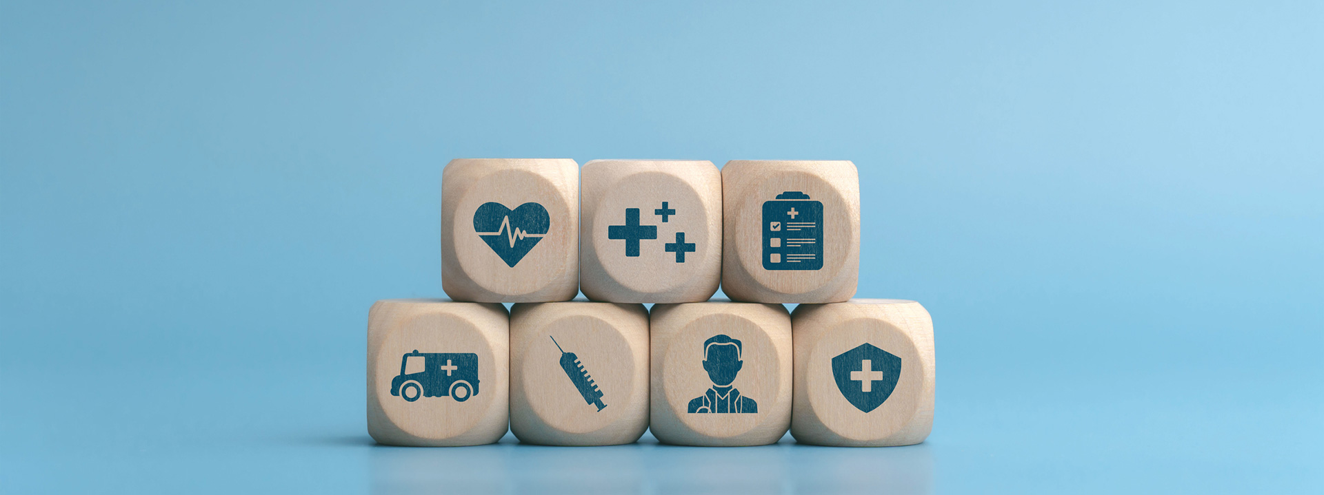 7 wooden blocks stacked with blue icons representing medical items