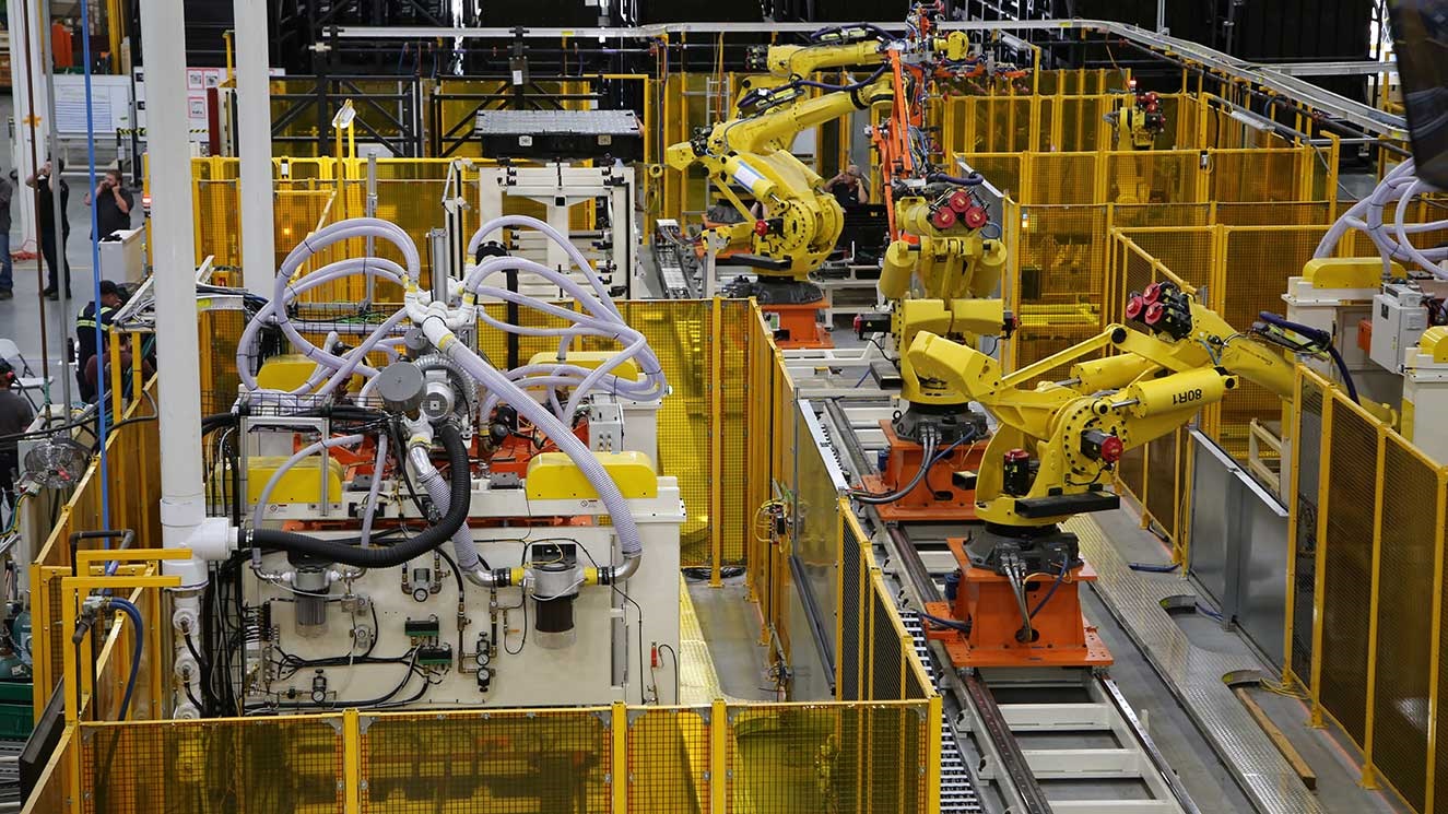 Robots on an assembly line in an automotive parts manufacturing facility