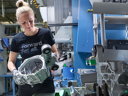 A person working on an assembly line in a car part manufacturing facility