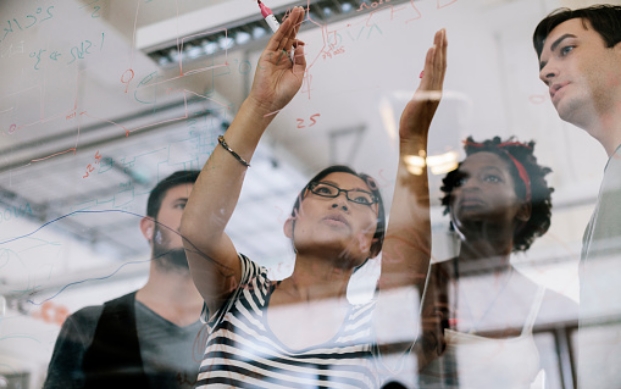 Team having a discussion near a glass dashboard
