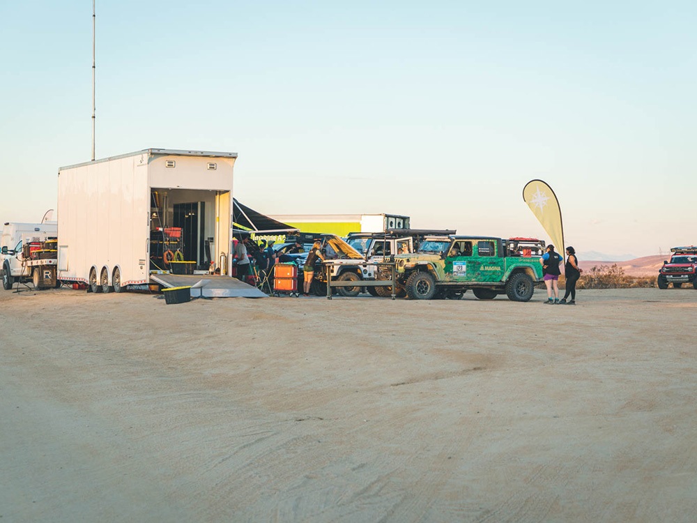 Group of vehicles parked and getting worked on during Rebelle Rally