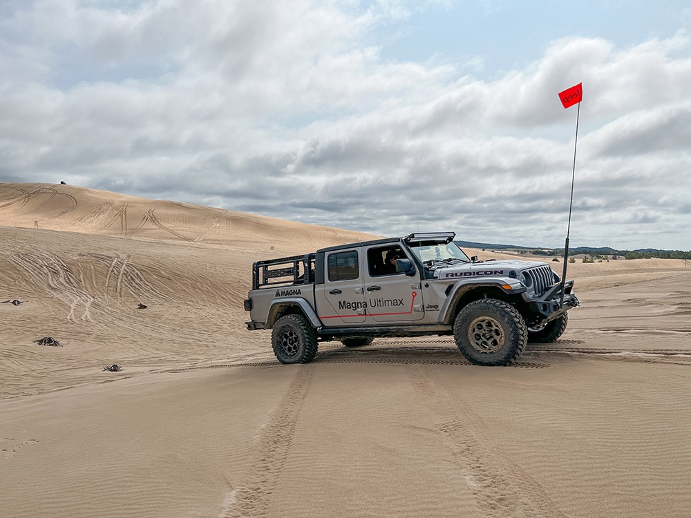 Two people driving a Jeep® Gladiator Rubicon along rugged terrain