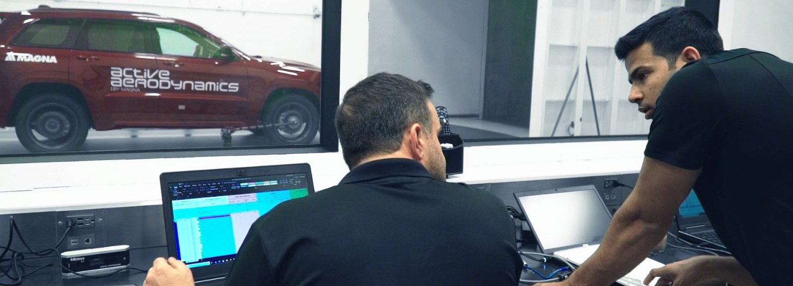 Two colleagues discussing in a car lab