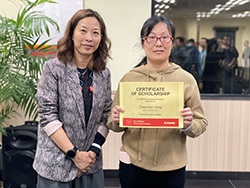 Two people standing together with one person holding a certificate