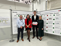 Group of standing together with a person in the middle holding a certificate