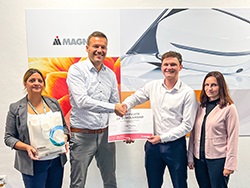 Group of standing together with two people in the middle holding a certificate and shaking hands