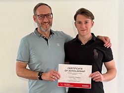 Two people standing together holding a certificate