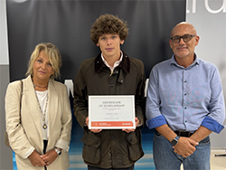 Three people standing together with the person in the middle holding a certificate
