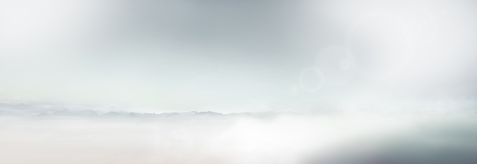 A soft, abstract landscape with subtle gradients of white and gray. The serene horizon evokes calmness and tranquility against a blurred foreground.
