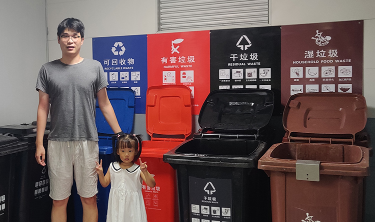 Shunwei Kang with daughter learning about recycling