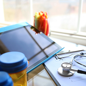 iPad, stethoscope, pill bottle and pad of paper