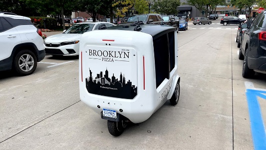 Photo of Delivery Bot driving down street
