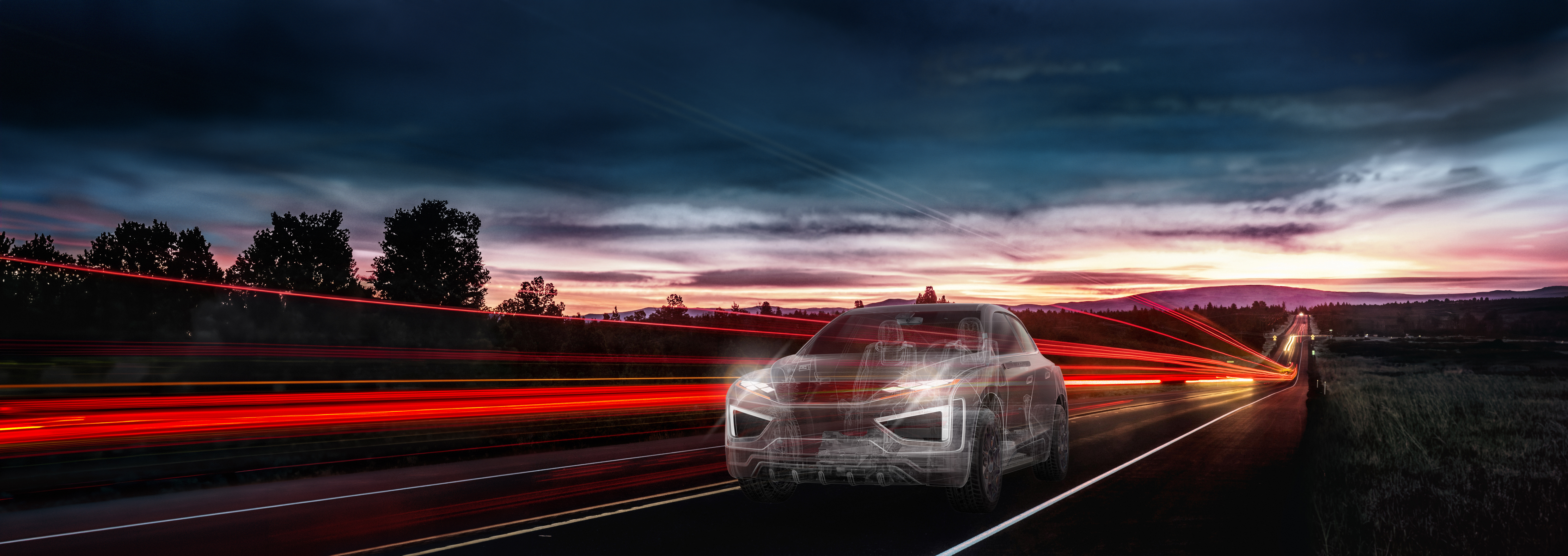 Ghosted vehicle driving along a road with fog and mountains in the foreground