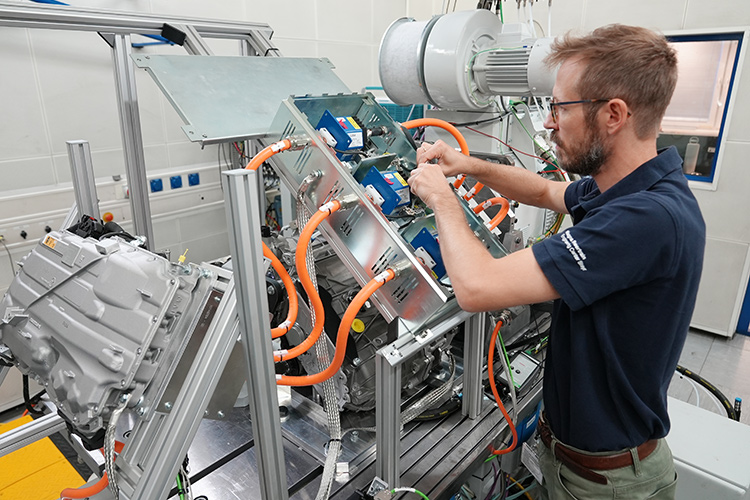 Person working on an eDrive testing machine in a manufacturing facility