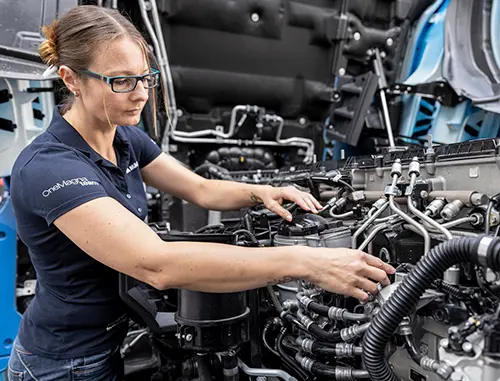Person working on a transmission in a manufacturing plant