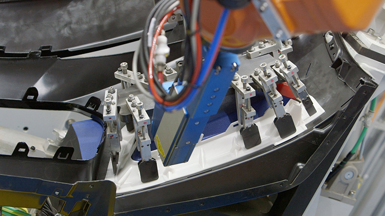 産業用ロボットが自動車部品を加工している様子