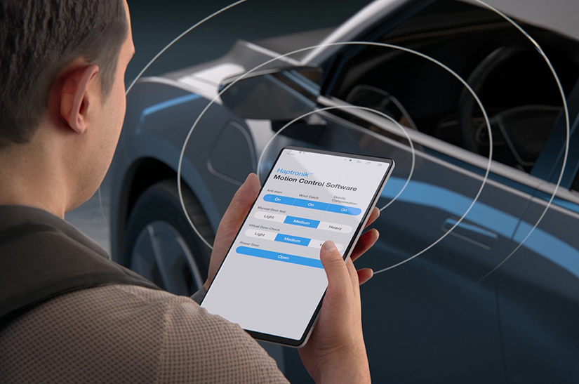 Person holding a smart phone outside of a vehicle with an app for the Haptronik Motion Control Software