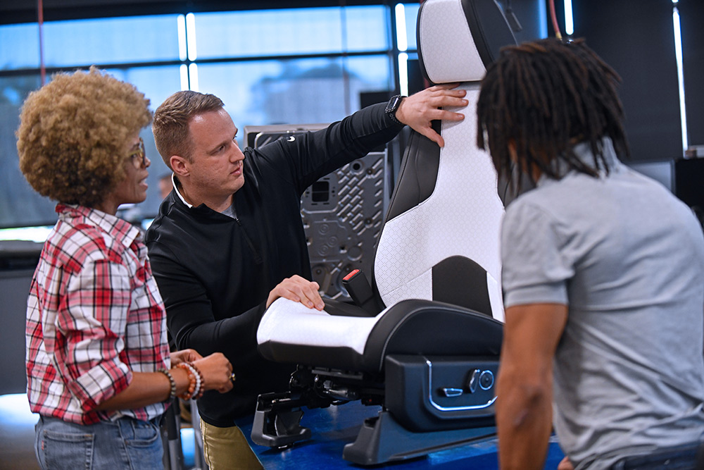 Group of people looking examining a black and white bucket car seat