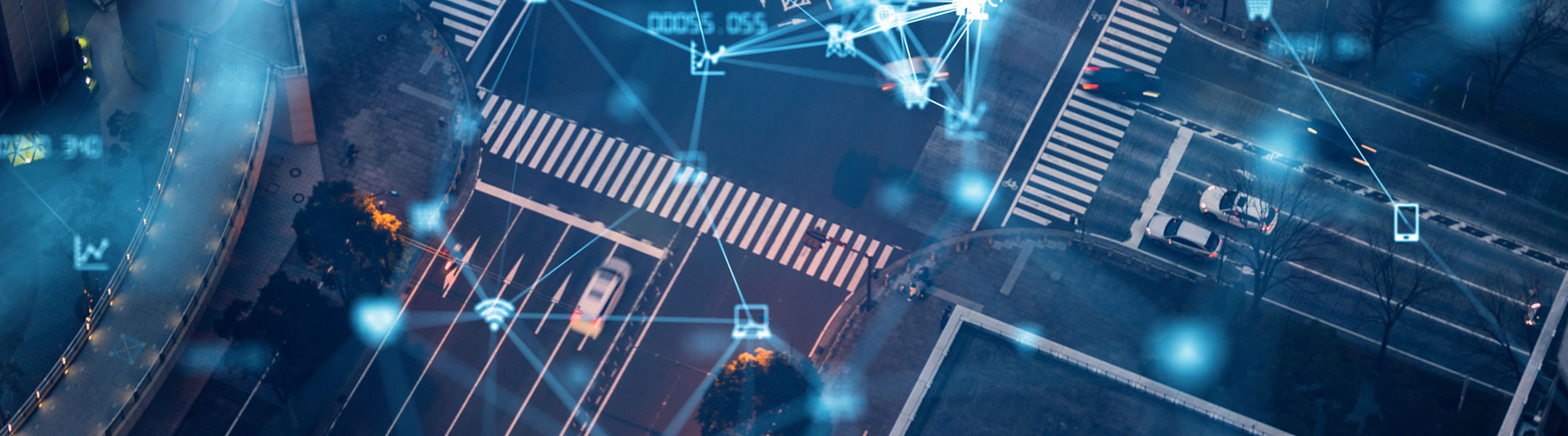 Overhead picture of a intersection of a road showing how technology works between cars and electronics