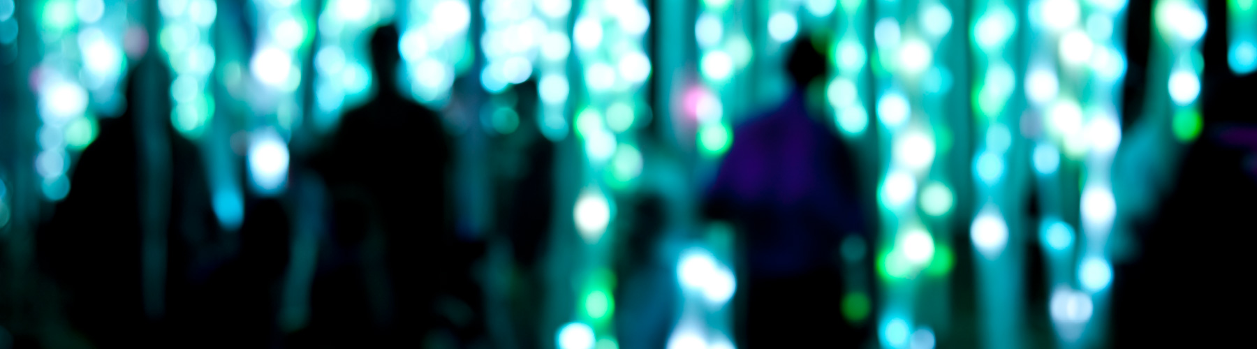 Blurred people standing in front of wall with lights