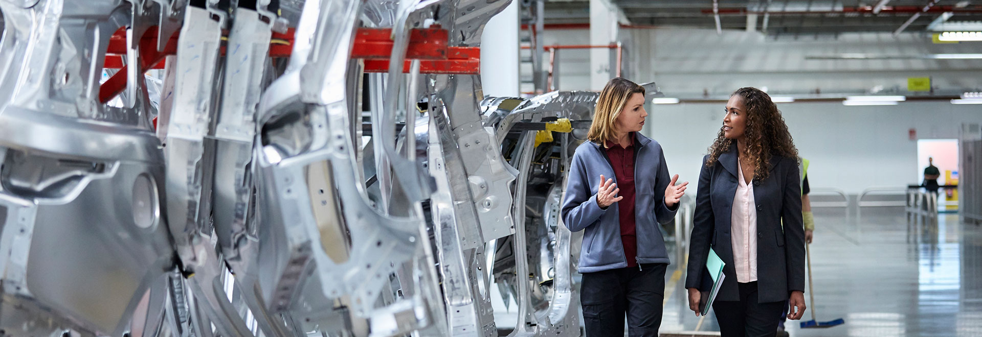 2 woman in a car production hall