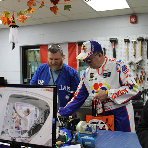 Paul Blackburn dressed in Nascar outfit with an employee at Polycon