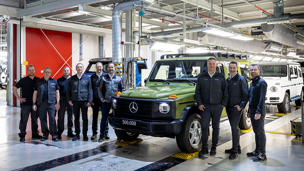 Group of people standing in front of a Mercedes G-Class in a Steyr manufacturing facility in Graz, Austria