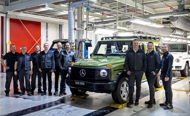 Group of people standing in front of a Mercedes G-Class in a Steyr manufacturing facility in Graz, Austria