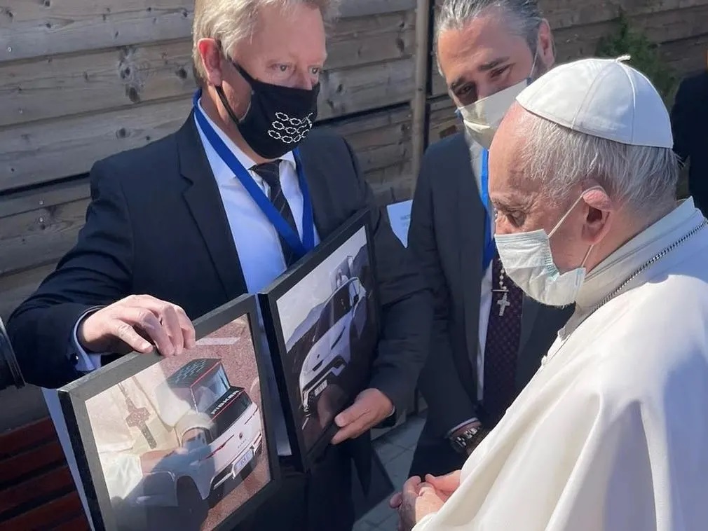 Pope Francis looking at pictures of the Popemobile