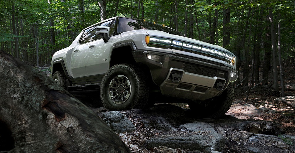Picture of a 2022 GMC Hummer EV driving across rugged terrain