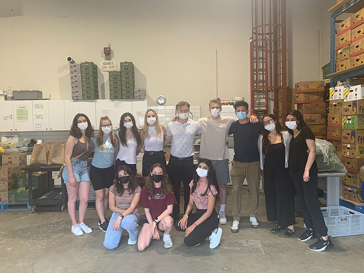 Group of people standing in a warehouse used to store food for a Food Pantry