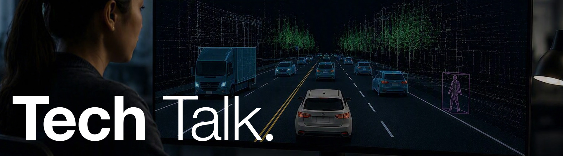 Black vehicle driving along a road at dusk with the sun setting, lake and city skyline in the background. With text Tech Talk.